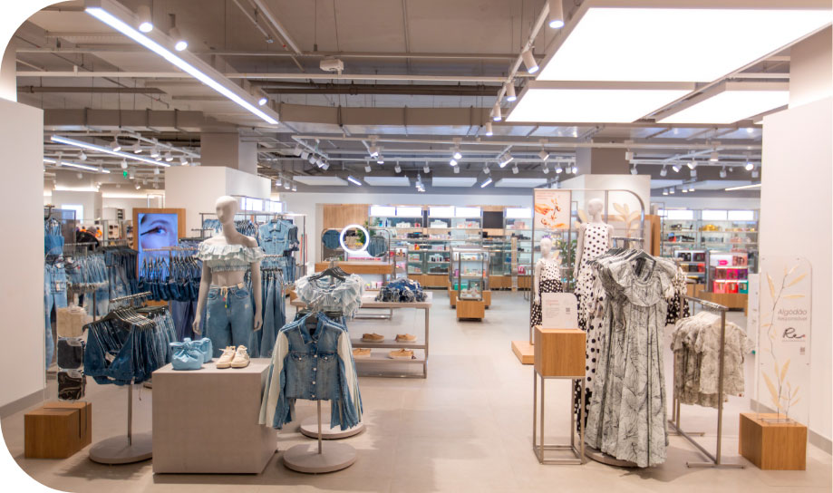 Imagem de um ambiente interno de uma loja com araras de roupas