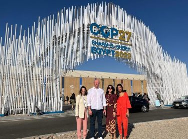 Grupo de pessoas em frente ao pórtico da COP-27