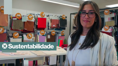 Mulher de ´´oculos em frente a amostras de tecido.